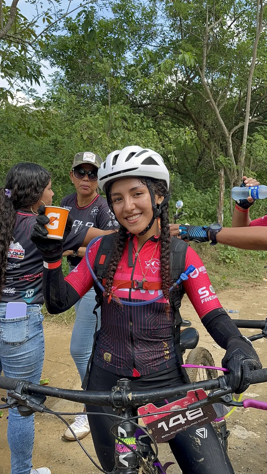 Rider sonriendo en punto de hidratación con uniforme Bololo.